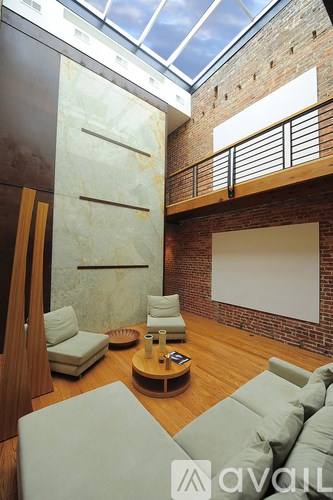 A living room with a glass ceiling and a wooden floor.
