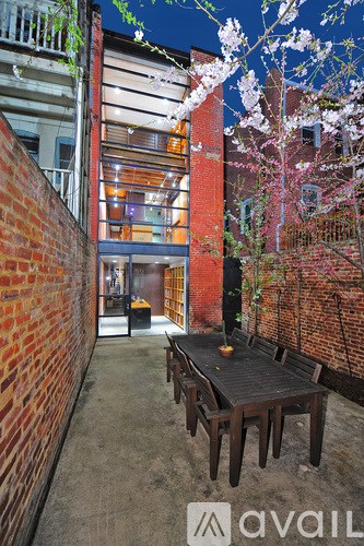 A patio with a table and chairs is surrounded by brick walls.