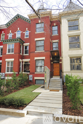 A red brick building with a green lawn in front.