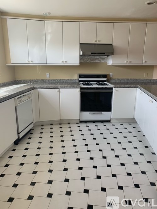 A kitchen with black and white tiles on the floor.
