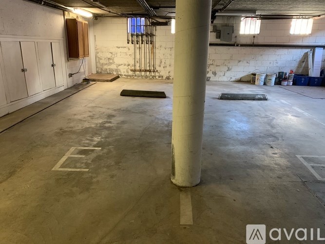A large empty room with a concrete floor and a white pillar in the middle.