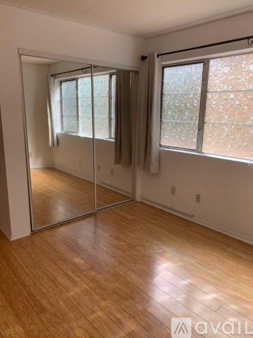 A room with wooden flooring and a sliding glass door.