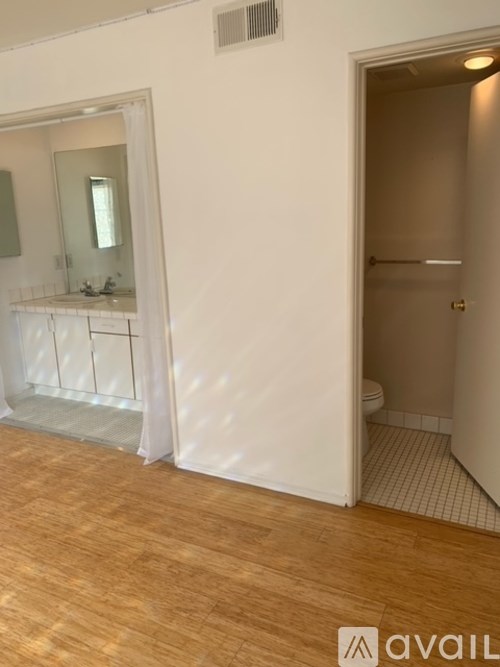 A bathroom with a toilet, sink, and mirror.