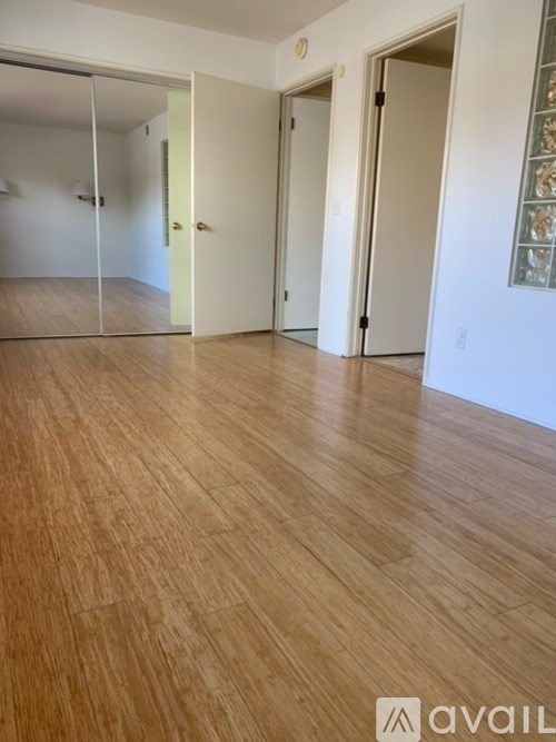 A room with wooden flooring and white walls.