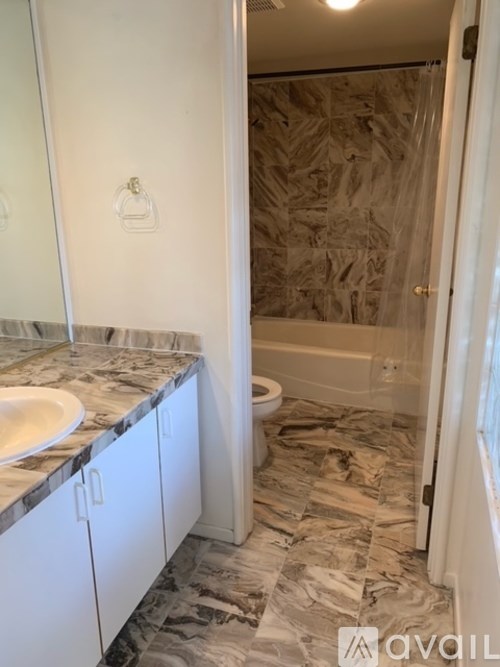 A bathroom with a marble countertop and a white toilet.