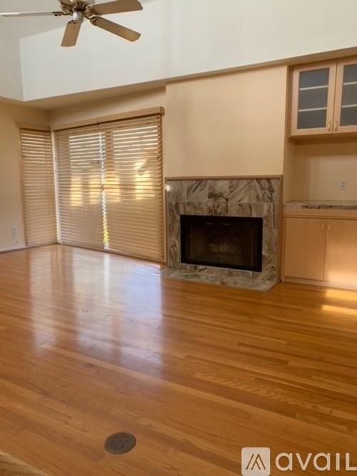 A living room with a fireplace and wooden floors.