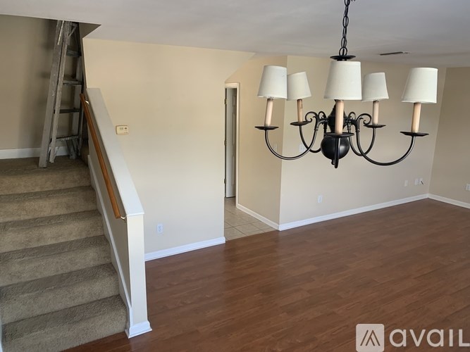 A living room with a chandelier and a staircase.