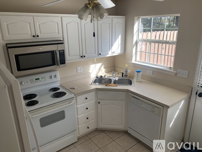 A kitchen with white appliances and cabinets.