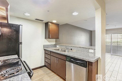 A modern kitchen with a black stove top oven and a granite countertop.