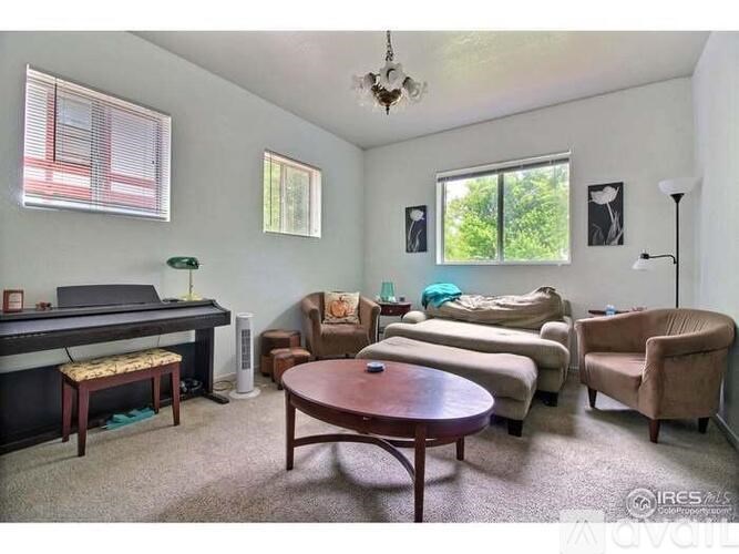 A living room with a piano, couches, and chairs.
