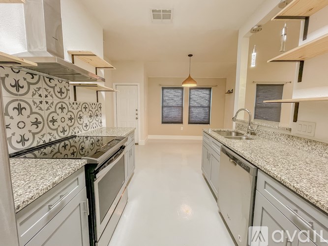 A kitchen with white cabinets and granite countertops.