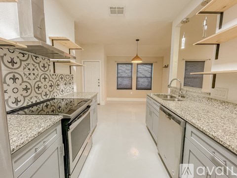 A kitchen with white cabinets and granite countertops.