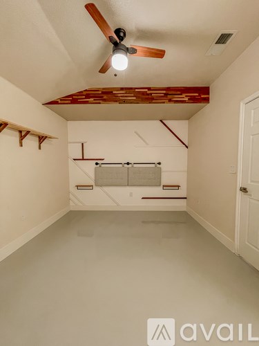 A room with a ceiling fan and a window with blinds.