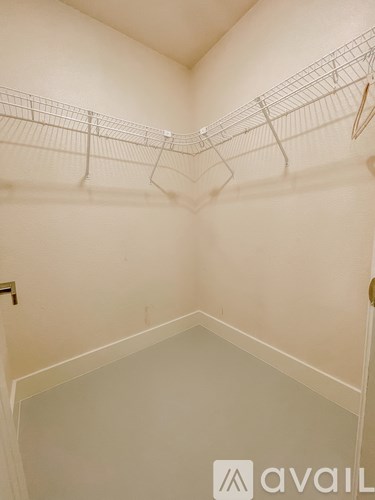 Empty white walk in closet with shelves.