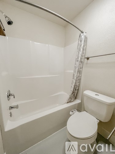 A white bathroom with a toilet, sink, and bathtub.