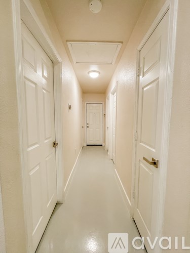 A long hallway with white doors on both sides.