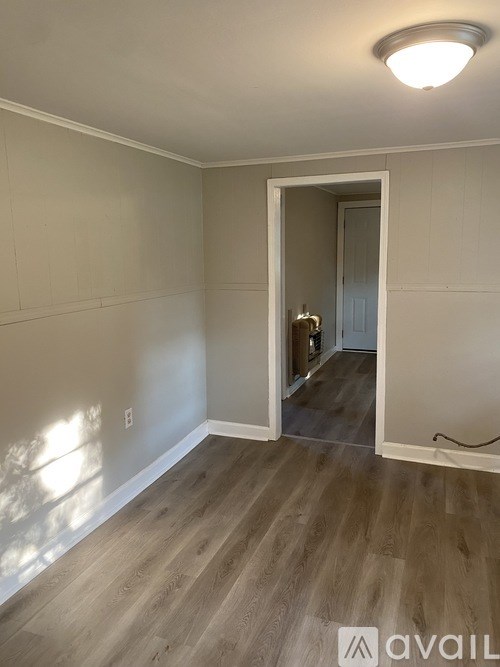 A room with a wooden floor and a white door.