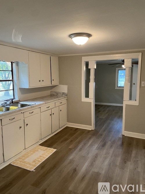 A kitchen with white cabinets and a sink.