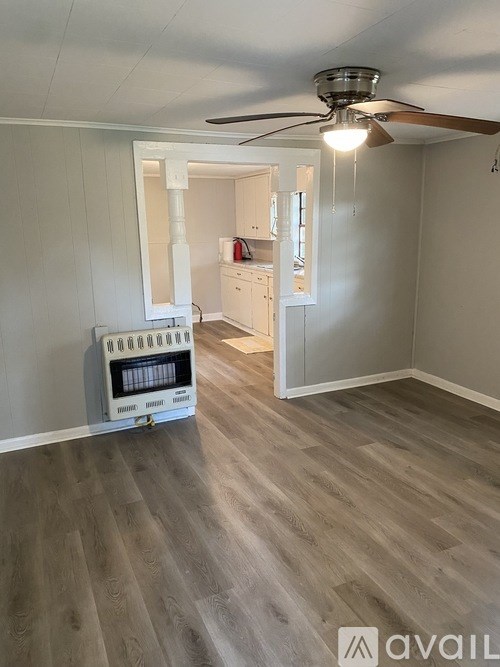 A room with a fan and a heater on the floor.