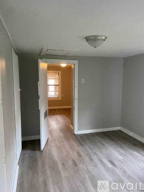A hallway with a door on the right and a window on the left.