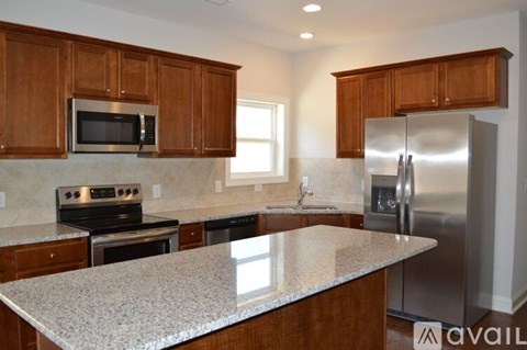 A kitchen with wooden cabinets and granite countertops.