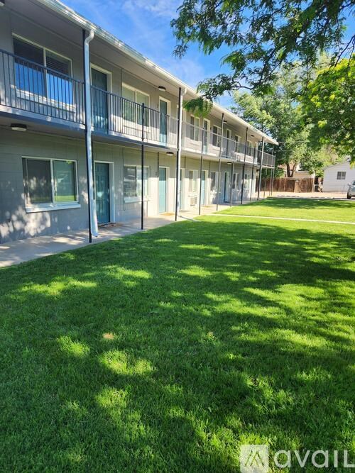 A sunny day at the grassy courtyard of a multi-story apartment building.