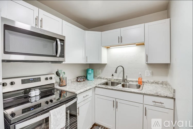 A kitchen with a stove, microwave, and cabinets.