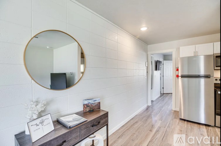A kitchen with a round mirror and a fridge.