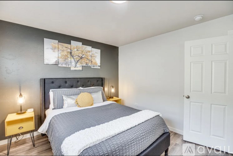 A bedroom with a large bed and a painting on the wall.