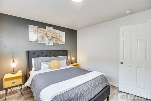 A bedroom with a large bed and a painting on the wall.