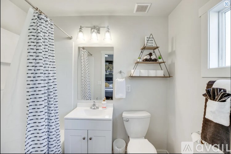 A bathroom with a white toilet, sink, and a shower curtain.