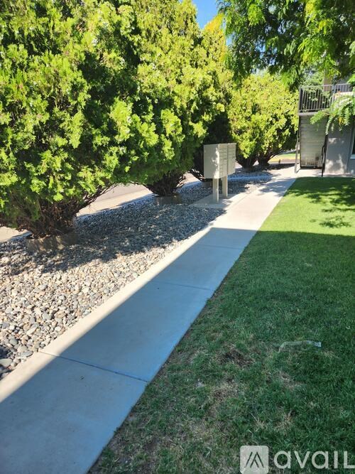 A sign is mounted on a post in a grassy area.