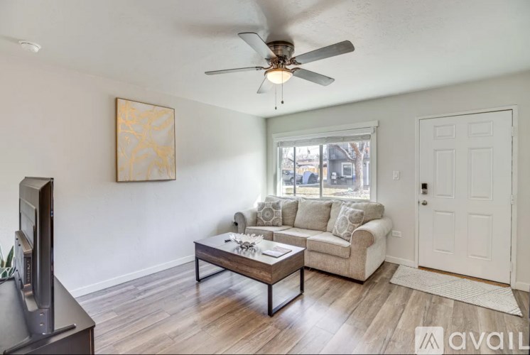 A living room with a couch, a coffee table, and a television.