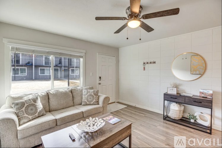 A living room with a couch, coffee table, and a ceiling fan.