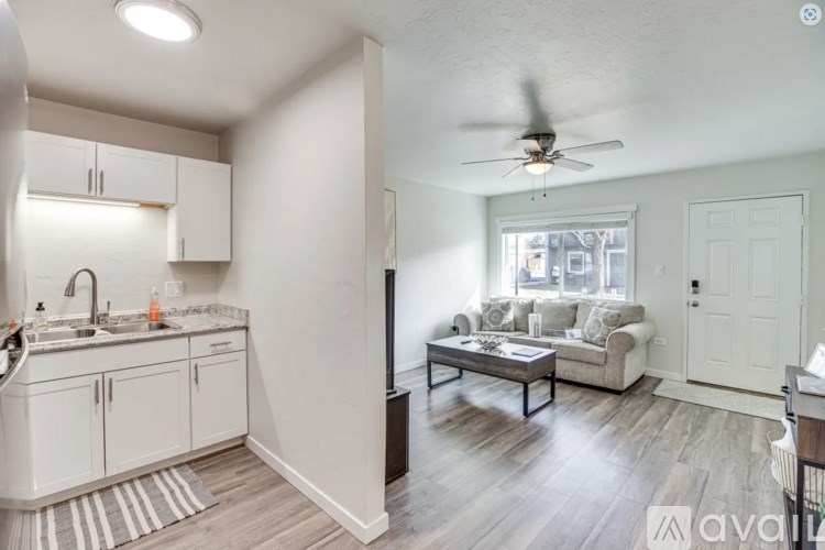 A well-lit kitchen with a dining area in the background.