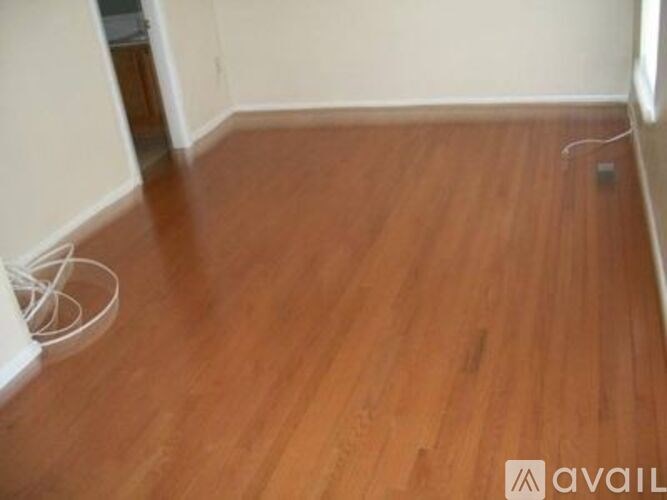 A room with wooden flooring and a white wall.