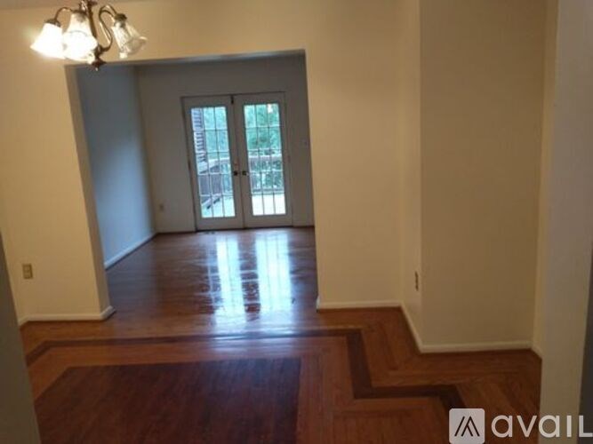 A room with a wooden floor and a chandelier.