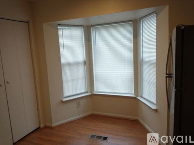 A room with two windows and a wooden floor.