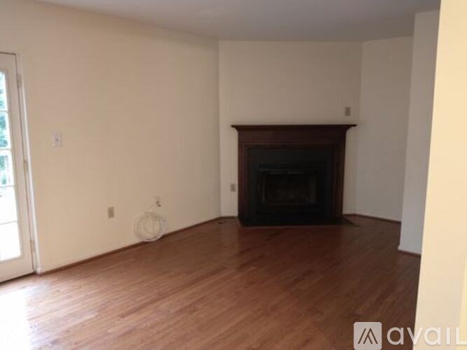 A living room with a fireplace and wooden floors.