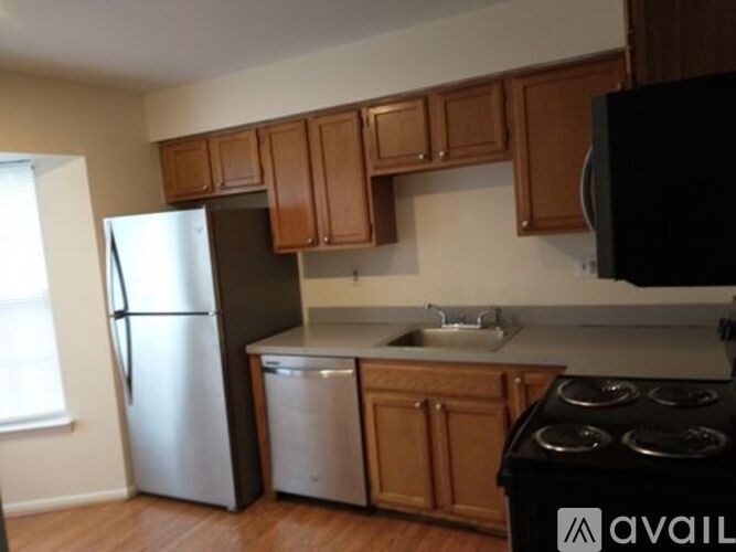 A kitchen with wooden cabinets and a black stove top oven.