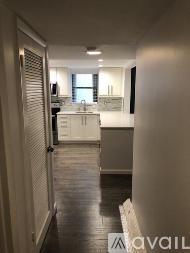 A kitchen with white cabinets and a window.