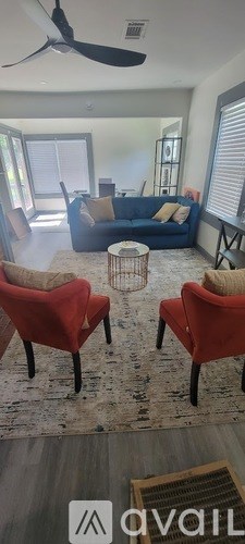 Two red chairs are placed in a living room.