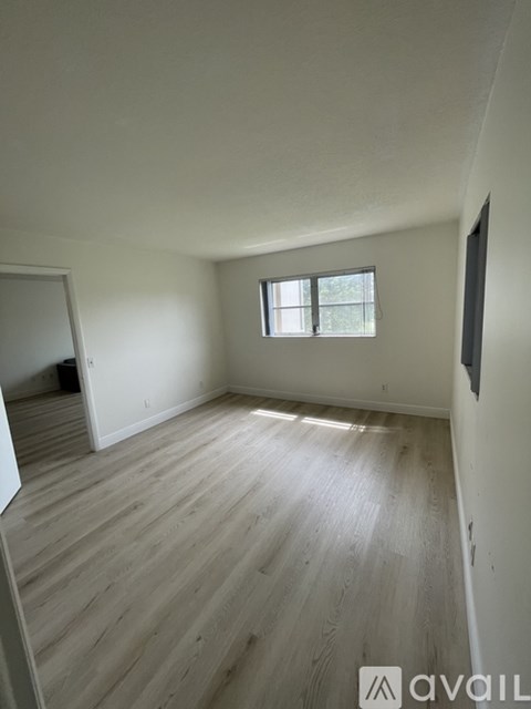 A room with wooden flooring and a window.