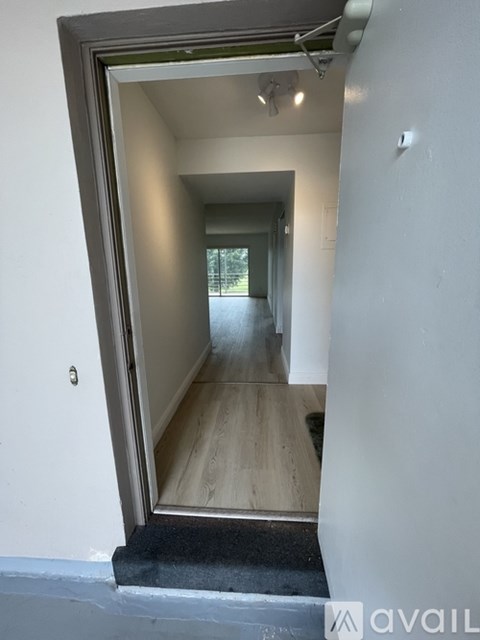 A hallway with a doorway leading to another room.