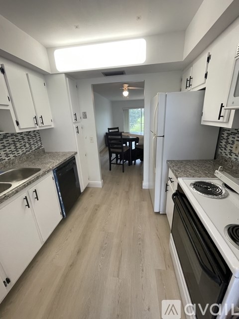 A kitchen with white cabinets and a black dishwasher.