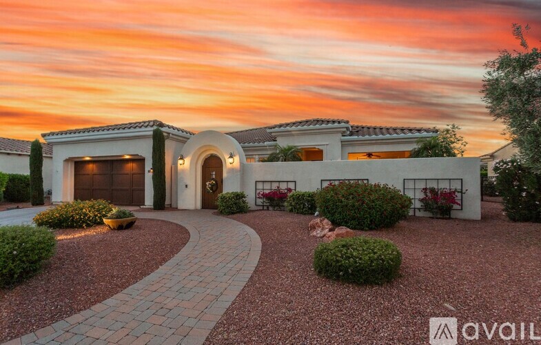 A house with a driveway and landscaping in front of it.