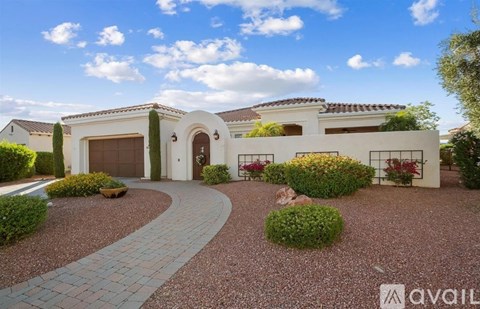 A house with a driveway and landscaping in front of it.