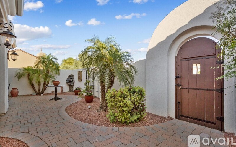 A house entrance with a brown door and a small garden.