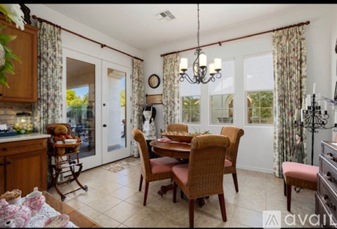 A dining room with a table set for a meal.