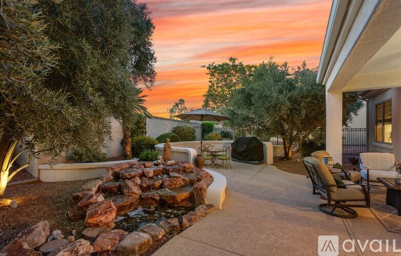 A backyard with a water feature and seating area.